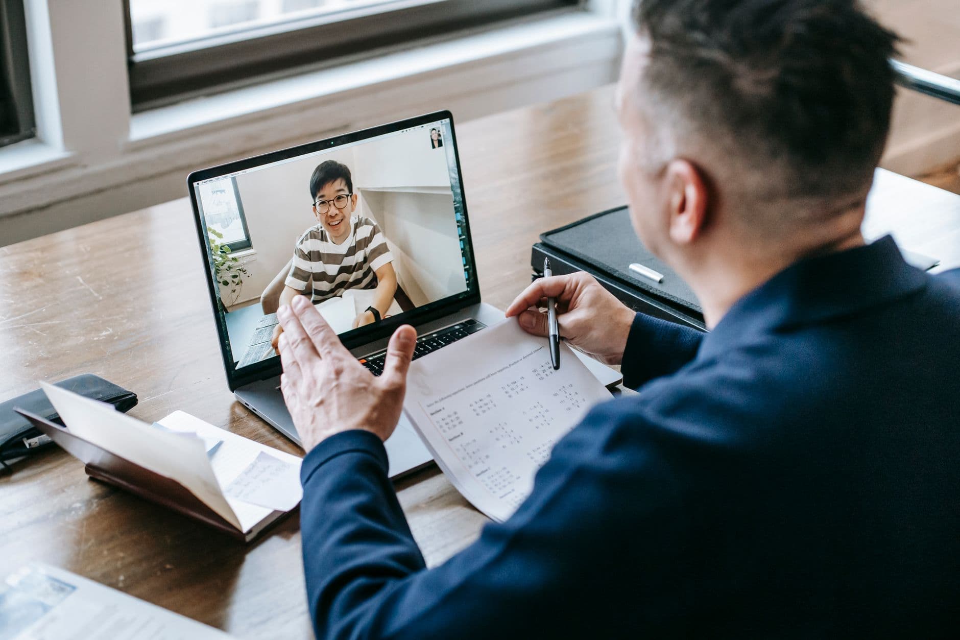 Ajuda de custo para home office é obrigatória? A professional having a video conference on a laptop from a home office, engaging in online communication.