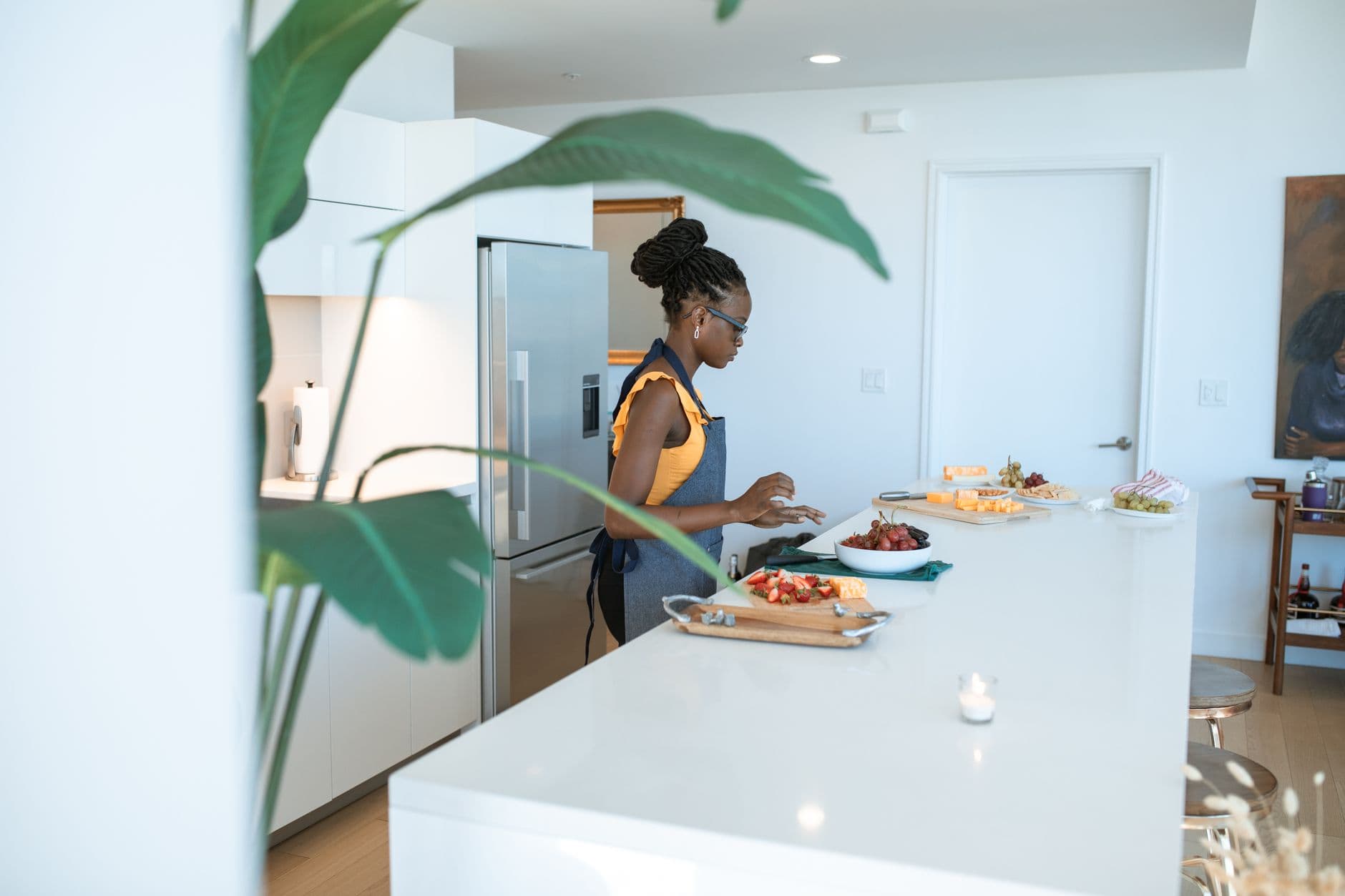 Alimentação saudável trabalhando de casa A woman preparing homemade dishes on a kitchen counter, creating a vibrant and modern domestic scene.
