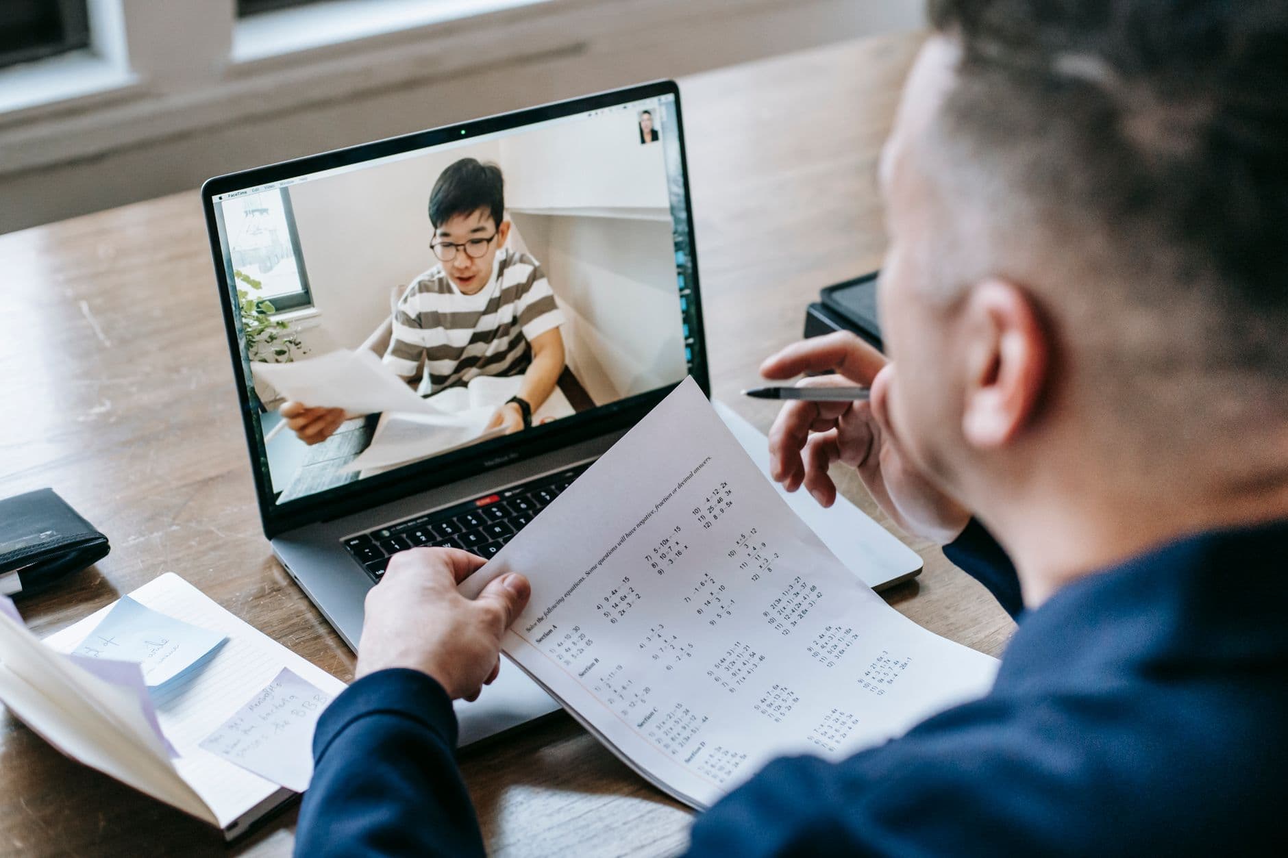 Profissional trabalhando em casa e conversando com a equipe por videochamada