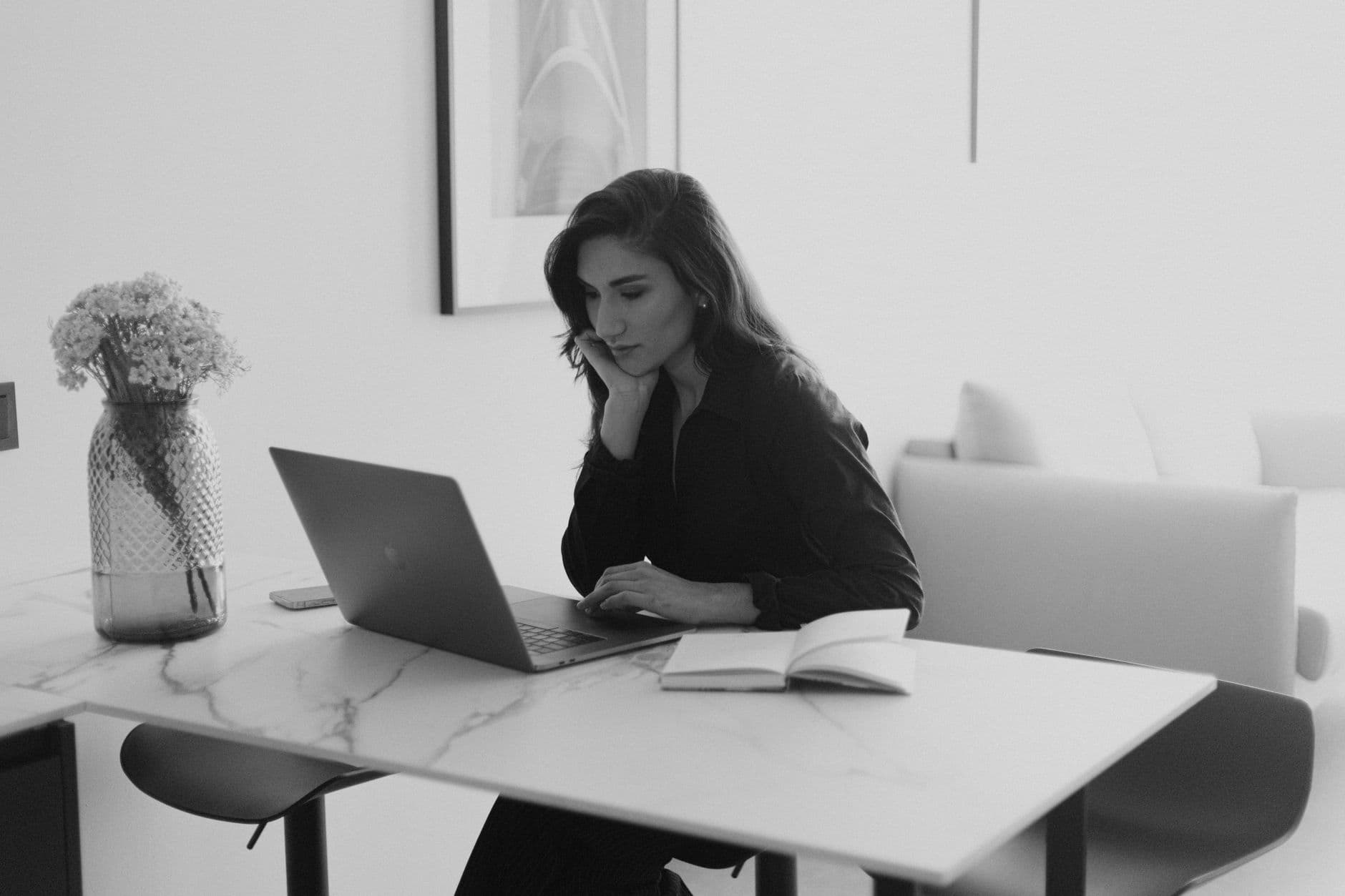 Como crescer na carreira trabalhando remoto Woman working on a laptop in a modern office, engaging in focused work.
