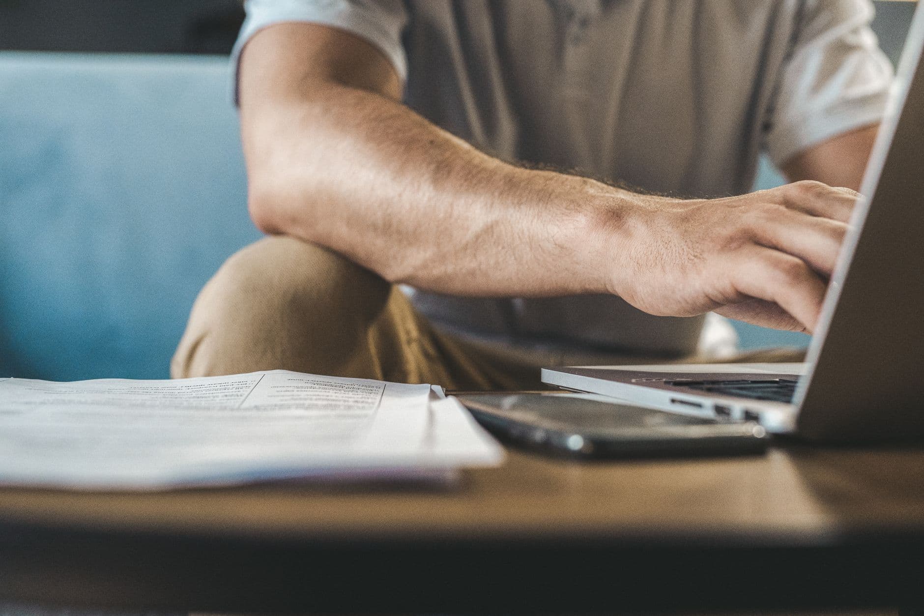 Freelancer remoto revisando documentos e mensagens de cobrança em uma mesa de trabalho