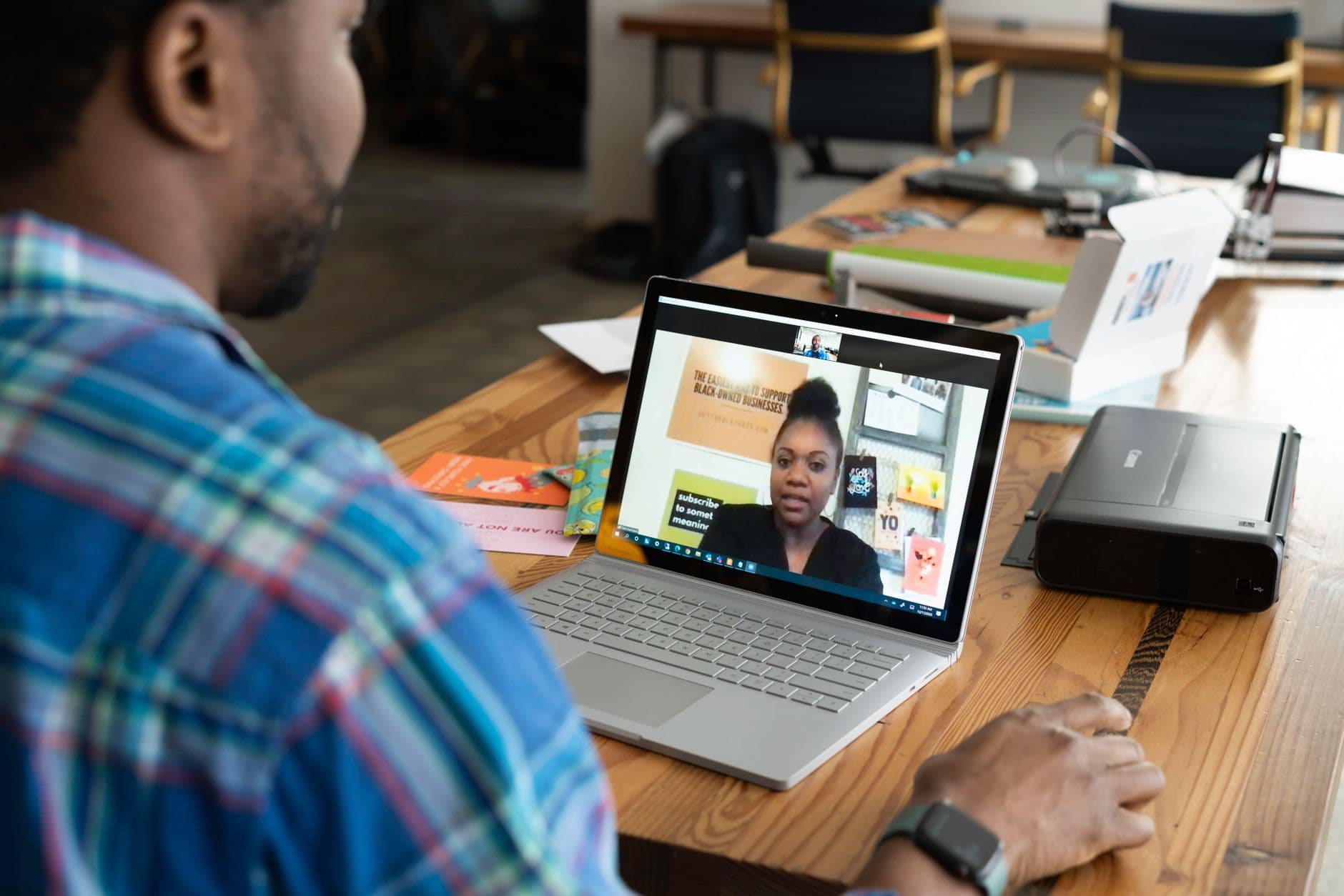 CLT home office: quais são seus direitos A businessman engaging in a virtual meeting using a laptop at an office desk.