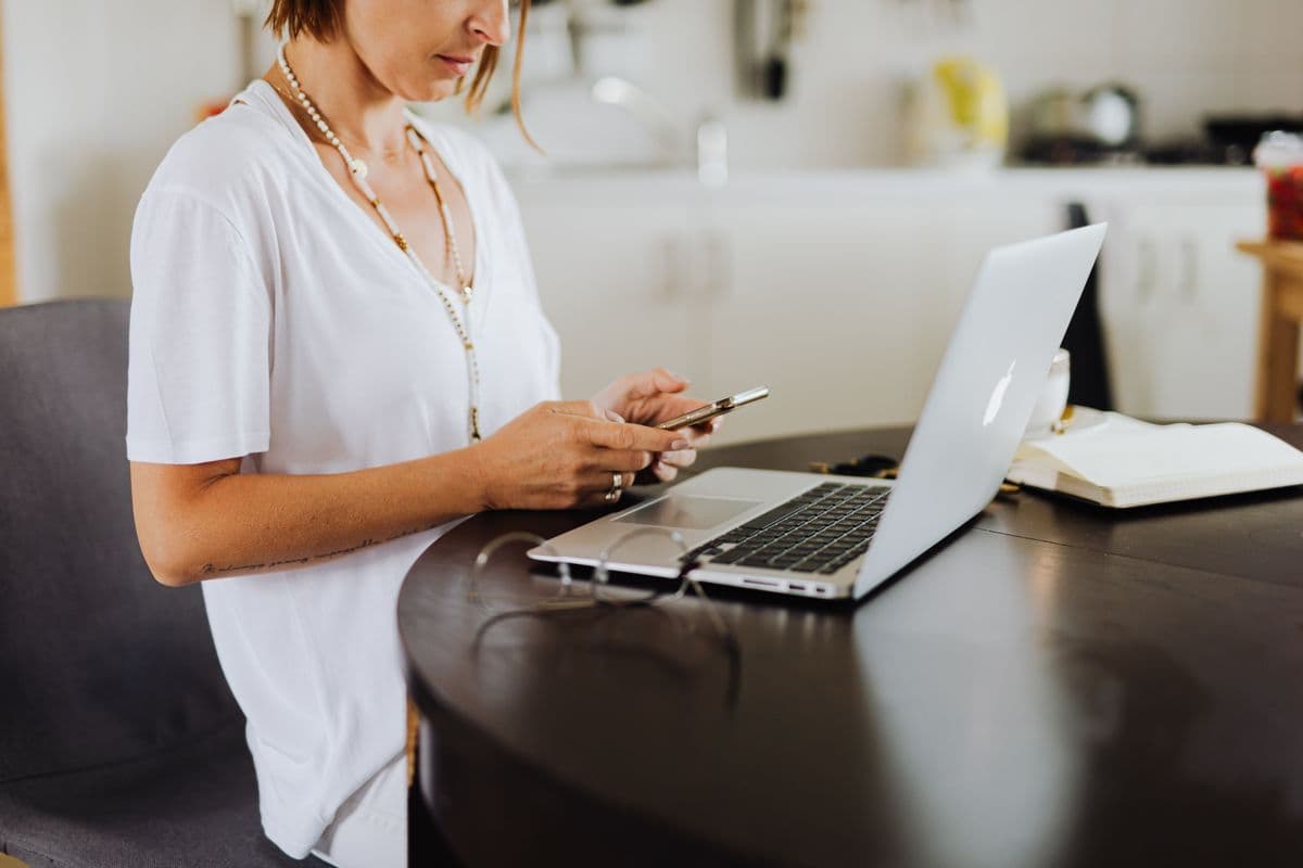 Pessoa analisando uma vaga remota no LinkedIn em um notebook sobre a mesa de home office.