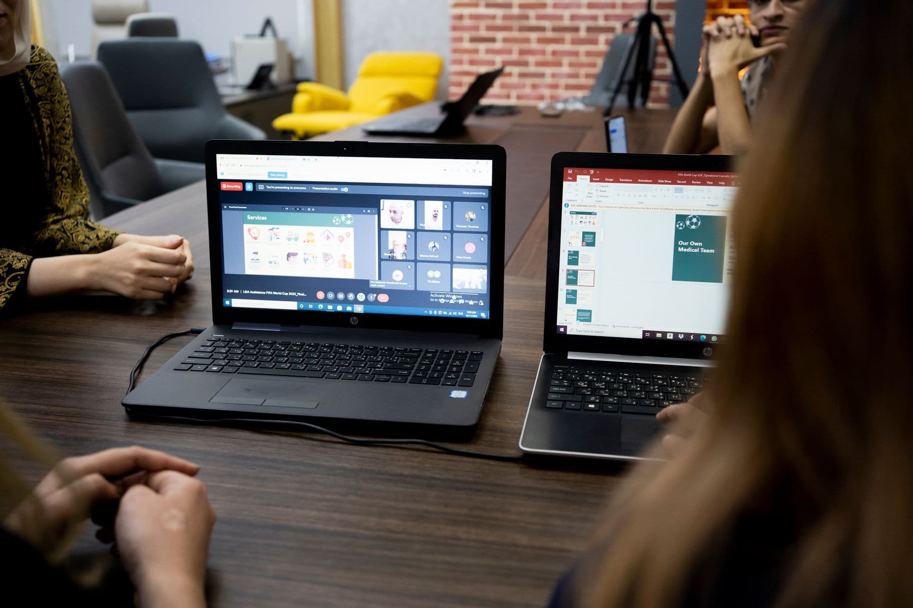 Profissionais trabalhando remotamente em laptops e acompanhando mensagens em um espaço de trabalho compartilhado.