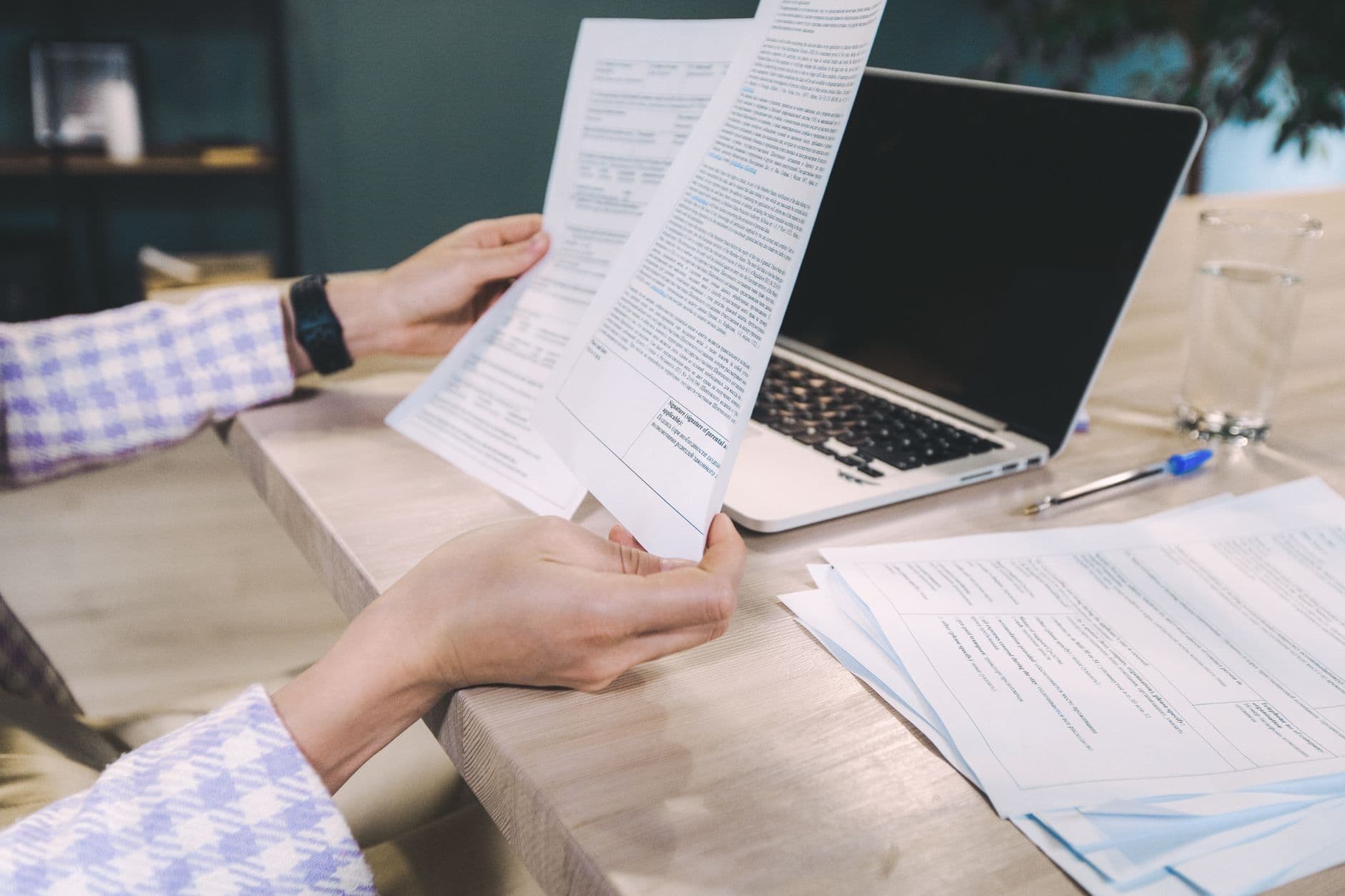 Freelancer revisando um contrato no notebook em uma mesa de home office