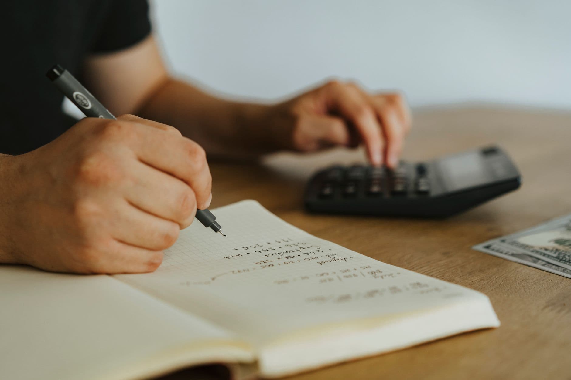 Freelancer organizando finanças em um laptop ao lado de documentos e uma calculadora