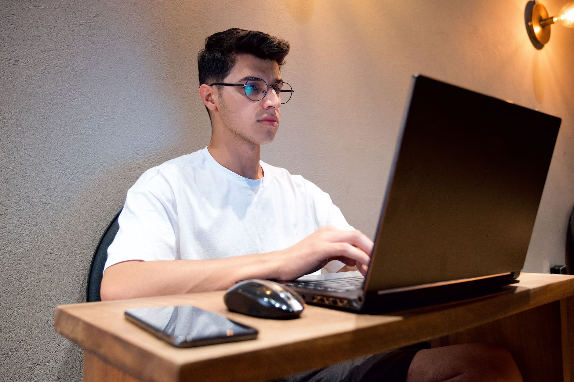 Profissional trabalhando em um projeto freelancer no laptop ao lado de sua estação de trabalho