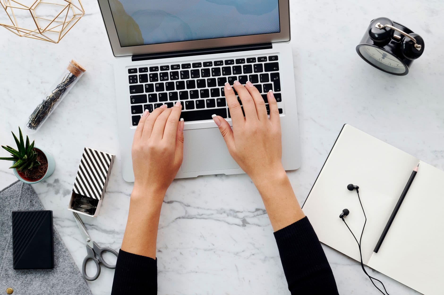 Profissional organizando tarefas em um quadro ao lado do laptop no home office