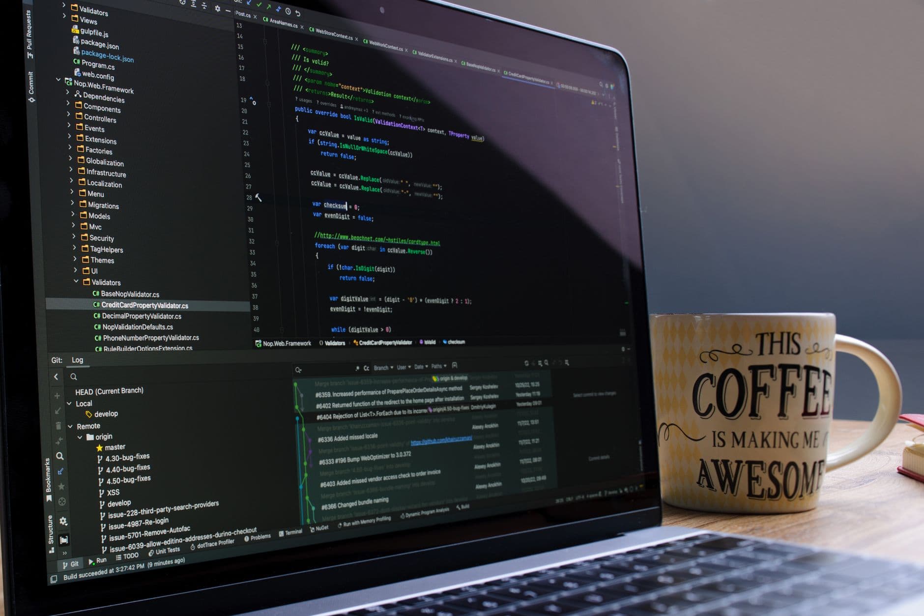 Como montar portfólio para vaga remota de tecnologia Close-up of laptop with coding software and a motivational coffee mug on a desk.